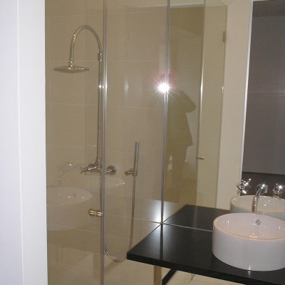 Dusche aus Glas in Wien neben einem weißen Waschbe